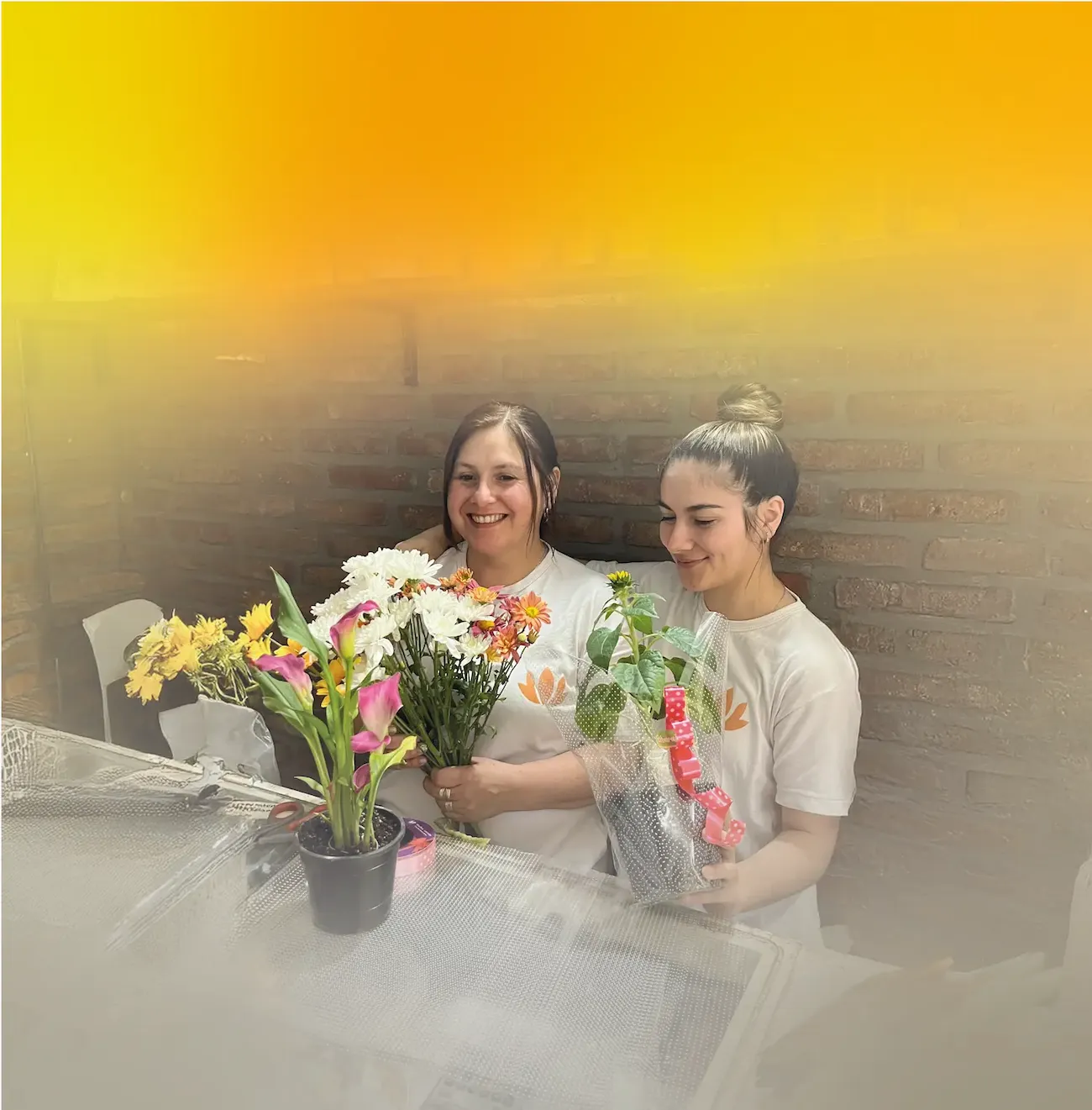 Imagen de la dueña de la tienda con una empleada preparando un ramo de flores